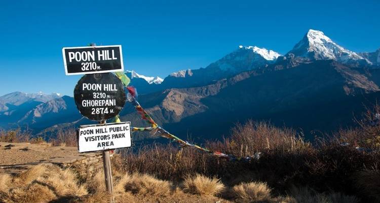 Panneau indicateur pour Poon Hill, avec une vue lointaine sur les montagnes.