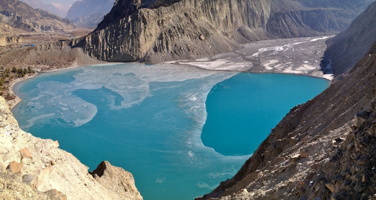Lago azul en medio de terreno accidentado coronado por colinas.