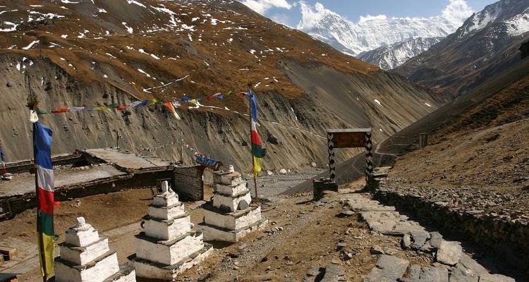 Mountain landscape with prayer flags and stupa.
