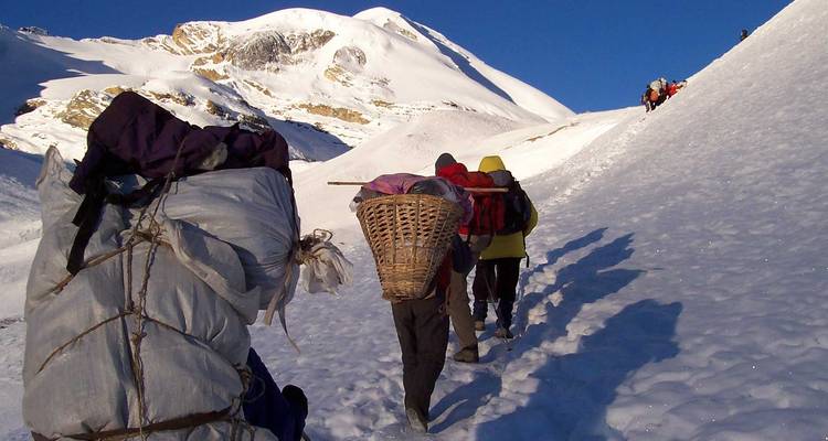 Group of hikers walking on snow-covered trail.