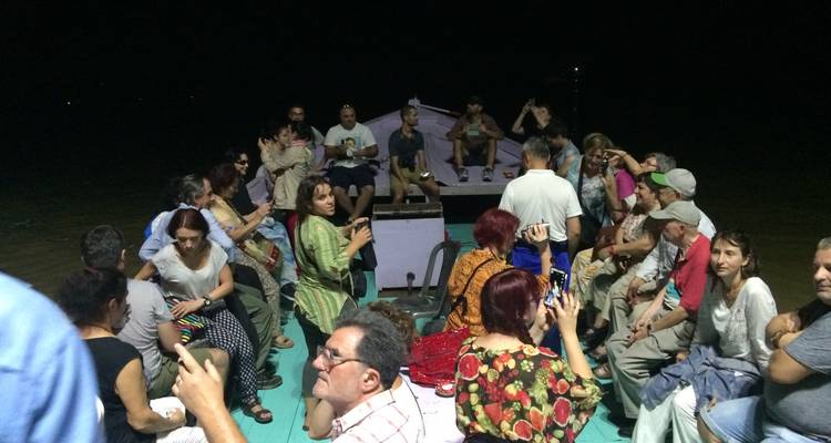 Eine Gruppe von Touristen bei einer nächtlichen Bootsfahrt.