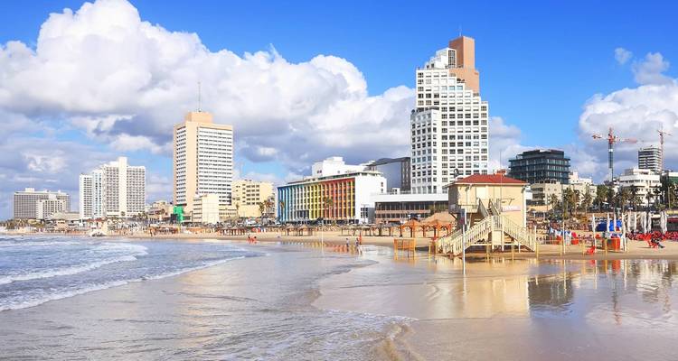 Strand-Stadtbild mit modernen Wolkenkratzern und Wellen.