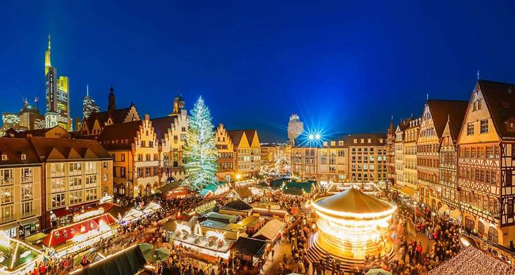 Marché de Noël festif avec un carrousel et un grand sapin de Noël.