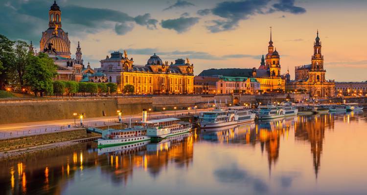 Dresden's historische skyline gloeit in de schemering met reflecties die schitteren op de Elbe