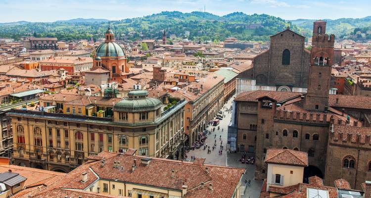 Panoramic rooftop view over Bologna’s terracotta roofs, domes and medieval towers on a sunny day