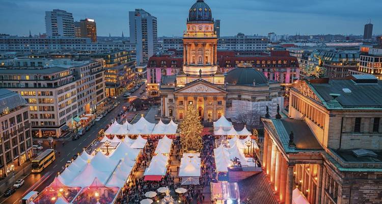 Christmas market in a city square at dusk.