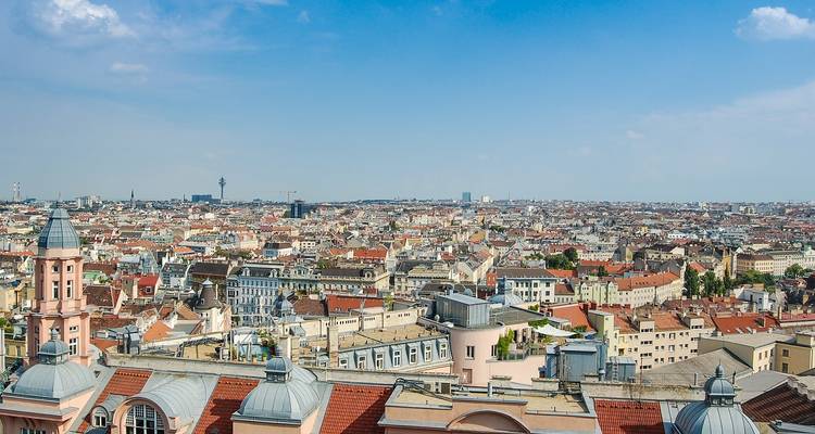 Panoramisch uitzicht van een uitgestrekte stadslandschap onder een heldere blauwe lucht.