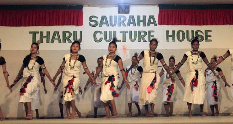 Des femmes exécutant une danse culturelle en tenue traditionnelle sur scène.
