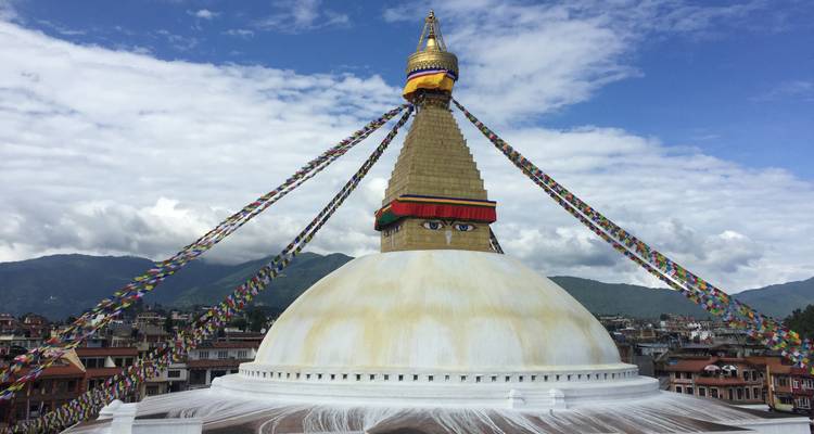Boudhanath Stupa met kleurrijke gebedsvlaggen en een heldere hemel.