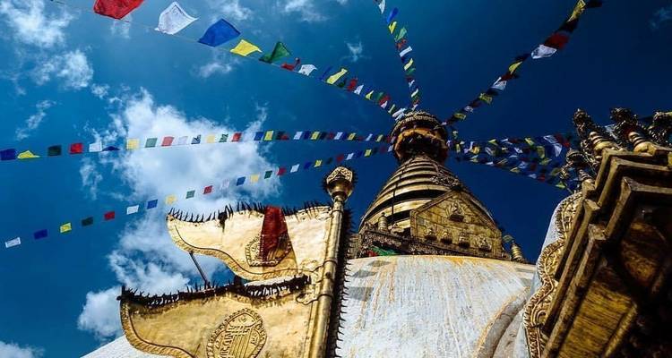 Close-up van de gouden torenspits van de Swayambhunath Stupa, versierd met gebedsvlaggen.