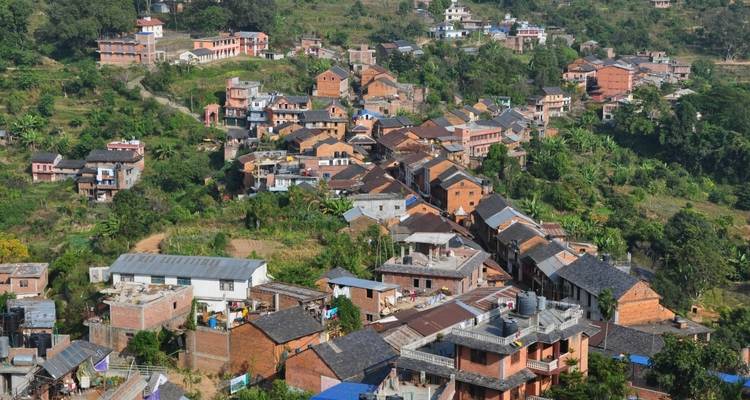 Cluster of buildings in a village with hills.