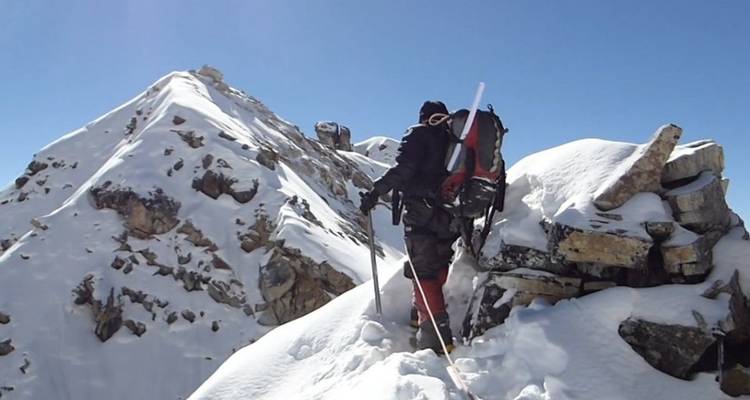 Klimmer die een besneeuwde bergkam bevaart.
