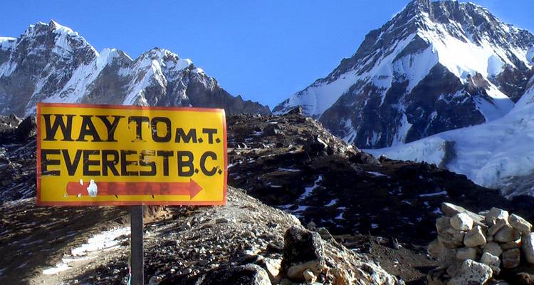 Panneau indiquant le camp de base de l'Everest avec des montagnes enneigées.