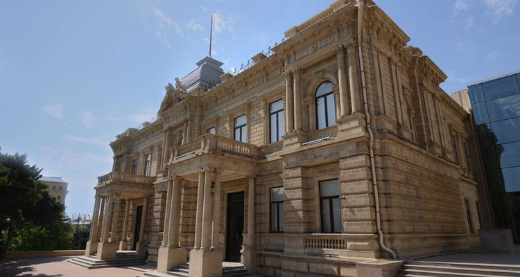 Historic building with classical architecture under a blue sky.
