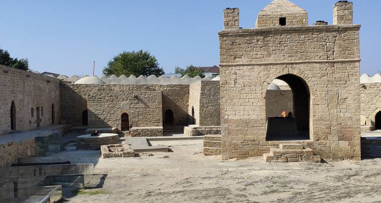 Old stone building complex with arches and exposed frames.