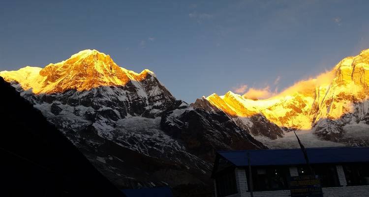 Gouden toppen van besneeuwde bergen bij zonsopgang.
