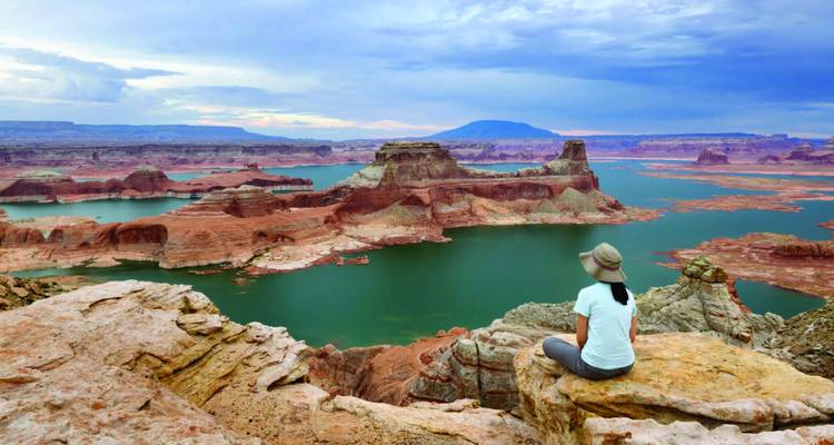 Personne assise qui admire un vaste paysage de canyon.