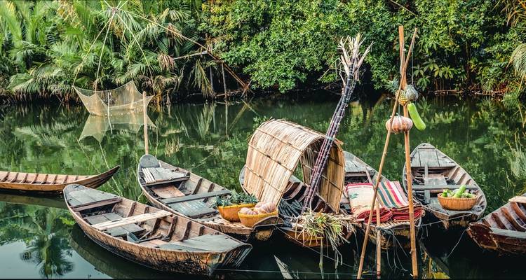 Bateaux traditionnels en bois avec filets de pêche dans un cadre fluvial paisible.
