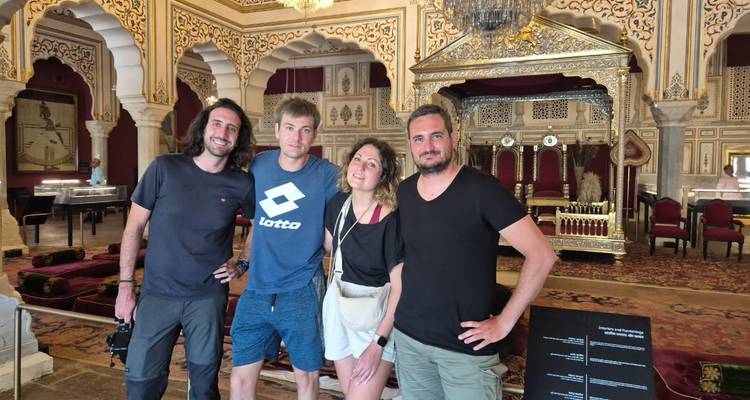 Group of people standing in an ornate Indian palace room.