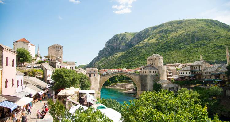 Iconic stone bridge over a river with scenic town view.