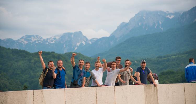 Group of joyful people posing with mountains in the background.