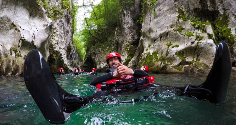 Person enjoying canyoning in a clear-water gorge.