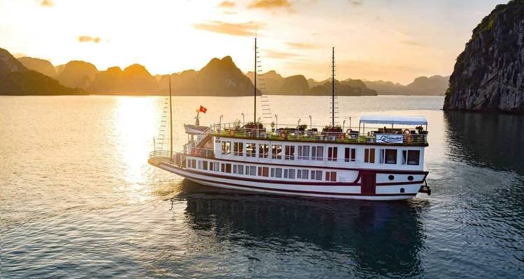 Un crucero navegando por la Bahía de Halong durante el atardecer.