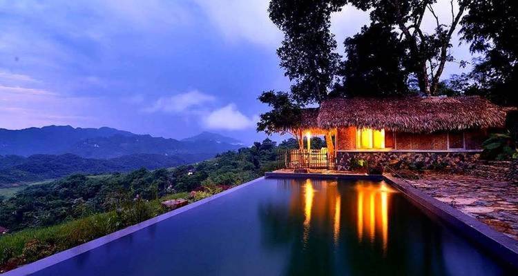 Hermosa piscina infinita con vista a un paisaje montañoso al atardecer