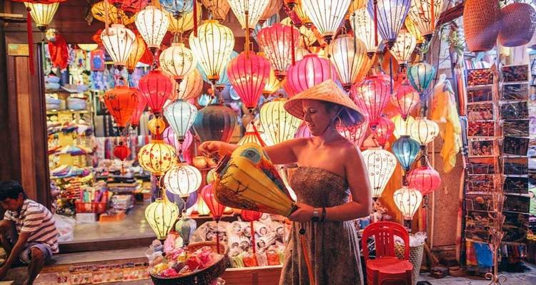 Woman in a market setting among colorful lanterns, likely shopping.