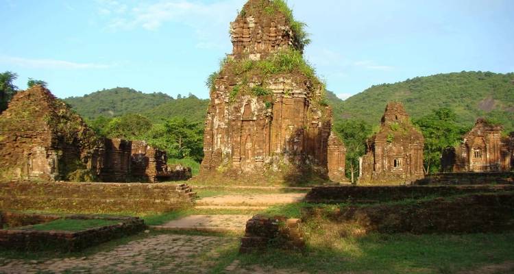 Ancient stone temple ruins set in a green landscape.