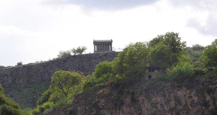 Fernblick auf einen Tempel auf einem Hügel, umgeben von Grün.