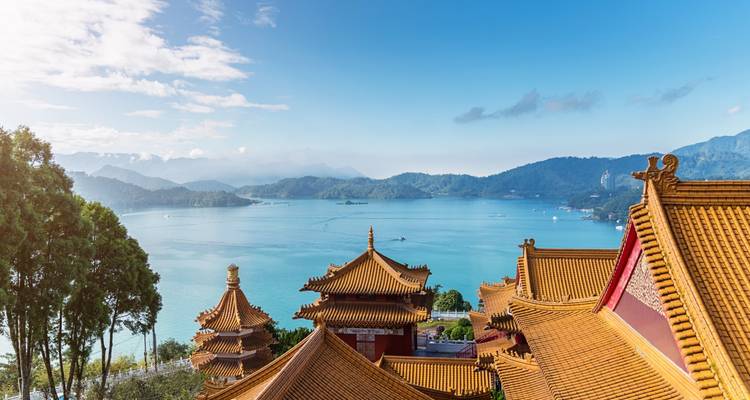 Lac du Soleil et de la Lune avec architecture asiatique traditionnelle et montagnes.
