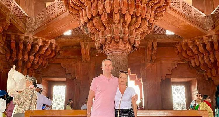 Twee mensen binnen in een historisch gebouw met ingewikkelde gravures.