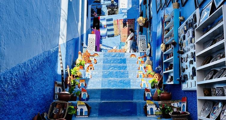 Escalera pintada de azul colorido con productos locales en exhibición.