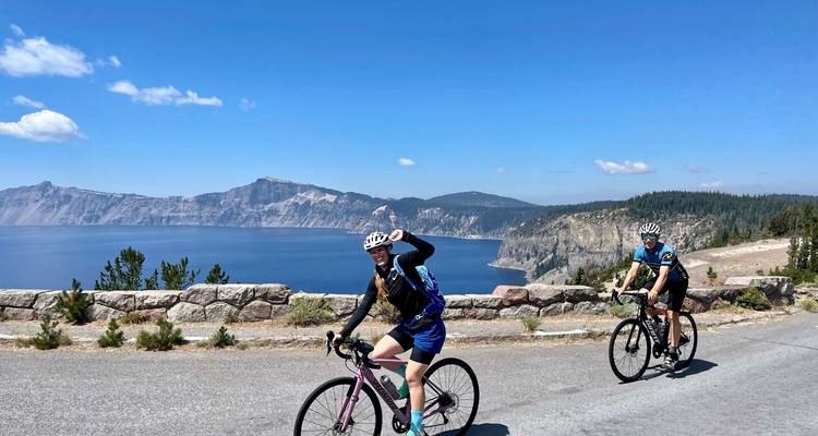 Cyclists riding along a scenic route by a lake.