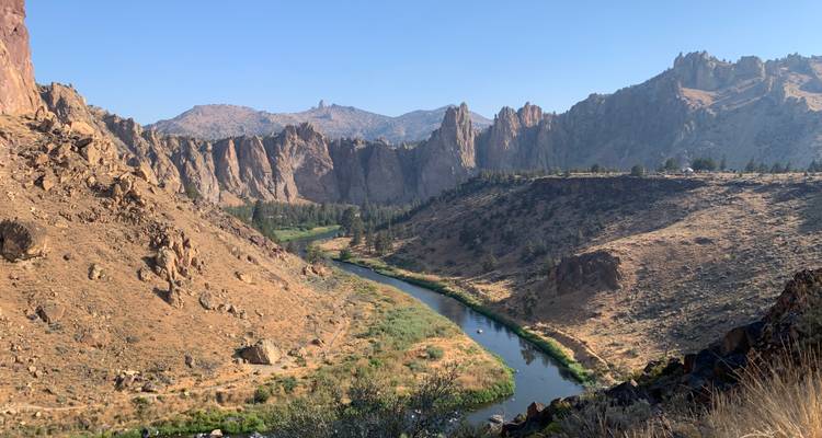 A winding river through a rugged landscape of cliffs.