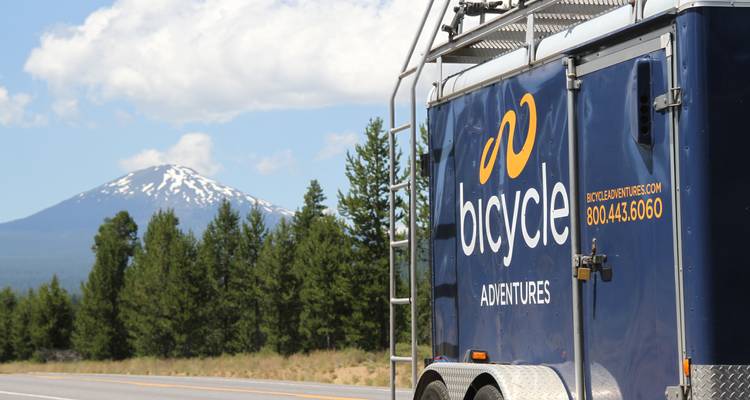 Remorque de vélo avec du texte et une montagne en arrière-plan.