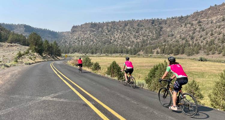 Des cyclistes sur une route entourée d'un paysage rocheux.