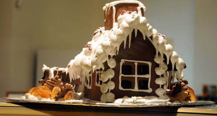 Maison en pain d'épices décorée d'un glaçage à la neige.