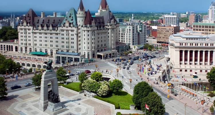 Scène animée du centre-ville d'Ottawa mettant en vedette le Château Laurier, le mémorial de guerre et des rues grouillantes d'activité par une journée claire.
