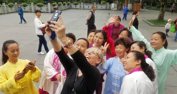 Gruppe von Menschen, die ein Selfie auf einem öffentlichen Platz machen.