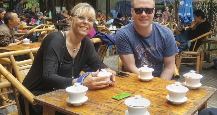 Zwei Personen genießen Tee in einem Straßencafé.