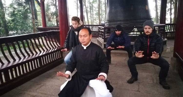 Small group meditating or practicing martial arts in a pagoda.