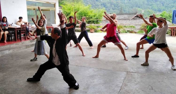 Group of people practicing tai chi led by an instructor.
