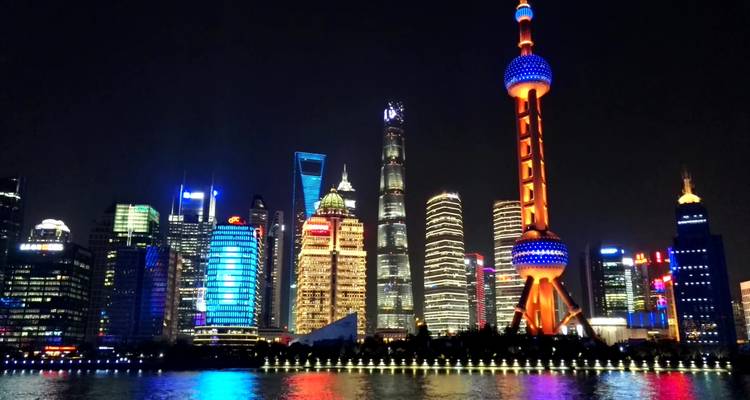 Nachtgezicht van Shanghai met verlichte skyline en reflectie.