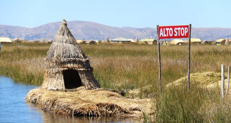 Une hutte de paille sur une île flottante avec un panneau stop au lac Titicaca.