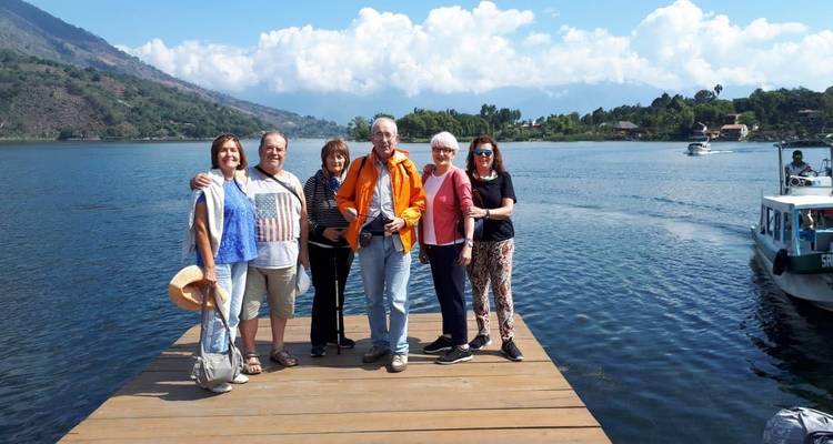 Groep mensen die op een houten steiger boven een meer staan.