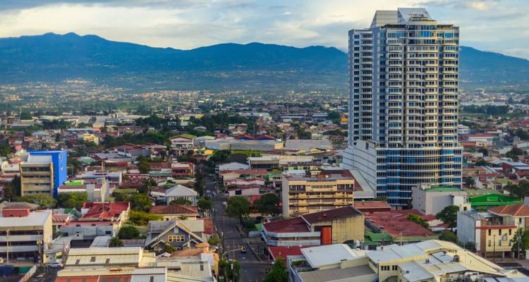 Vista panorámica aérea del paisaje urbano de San José con rascacielos modernos y montañas circundantes
