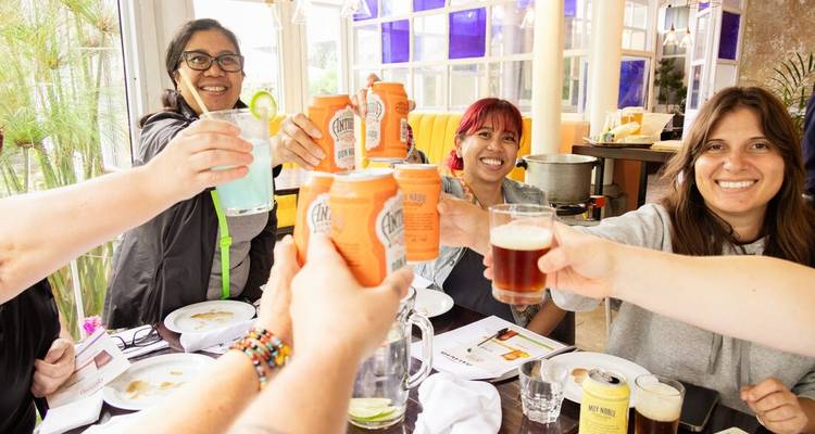 Groupe de personnes trinquant avec des boissons à une table.