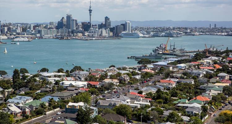 Vista de los suburbios de Auckland y el horizonte del centro de la ciudad a través del puerto azul en un día soleado.